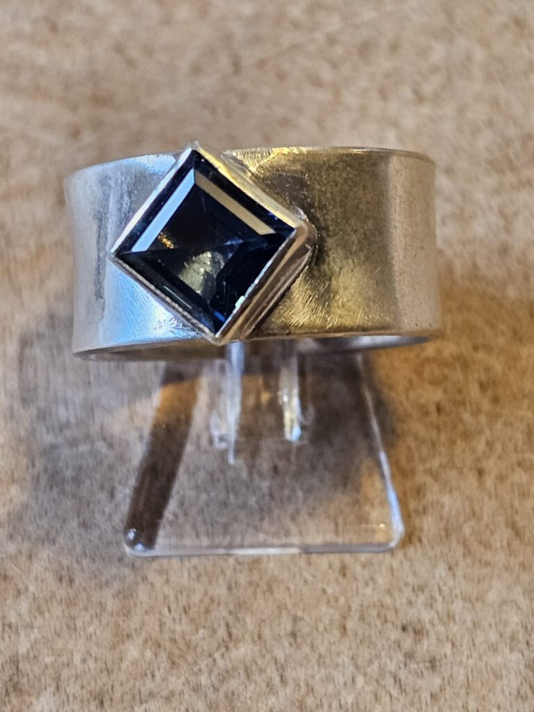 Ring mit blauem quadratischem Stein.